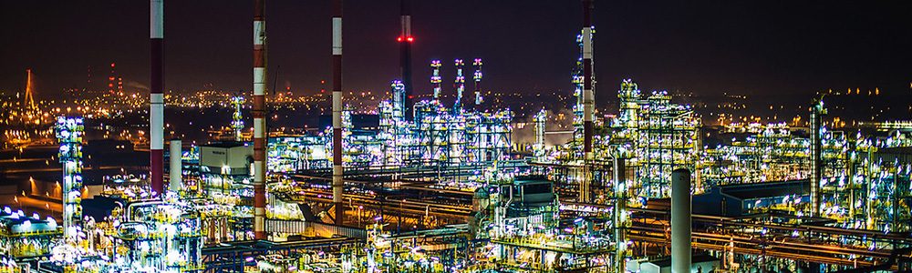 Two petrochemical contractors closing a deal in front of an oil refinary